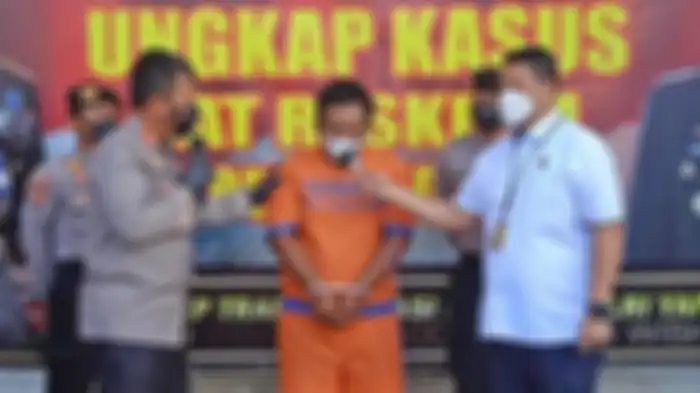 Pelaku yang membakar istri dan anaknya saat digelandang polisi di Polresta Sidoarjo. 