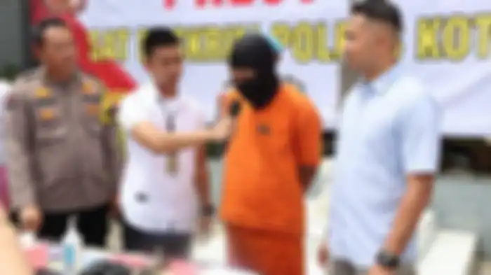 Petugas Polresta Tangerang menunjukkan tersangka B, seorang pria asal Kepulauan Riau, yang melakukan kejahatan pemerasan belasan juta rupiah dengan menyamar jadi wanita untuk melakukan video call asusila, yang dikenalnya lewat aplikasi MiChat, Jumat (9/12/2022).  