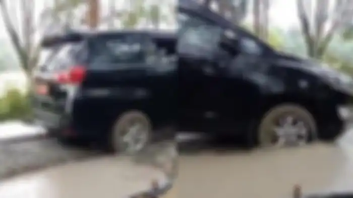 Mobil dinas Kepala Dinas Pemuda dan Olahraga (Kadispora) Lubuklinggau menerobos jalan cor yang masih basah.