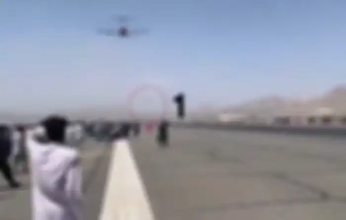 Foto ini merekam 2 warga Afghanistan yang jatuh dari pesawat militer Amerika Serikat (AS) usai bergelantung di bagian roda. 