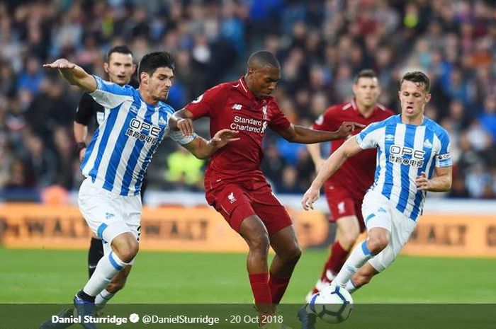 Striker Liverpool, Daniel Sturridge, berjibaku mempertahankan bola saat dikepung pemain Huddersfield Town dalam laga lanjutan Liga Inggris pada Sabtu (20/10/2018) di Stadion John Smith.