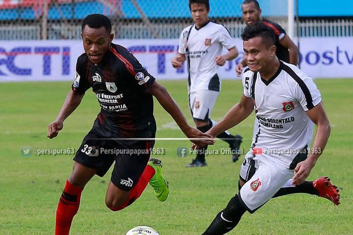 Pemain Persipura, Gunansar Mandowen (kiri) saat adu lari berebut bola dengan pemain Persidago pada leg kedua 32 besar Piala Indonesia 2018 di Stadion Mandala, Jayapura, 8 Februari 2019. 