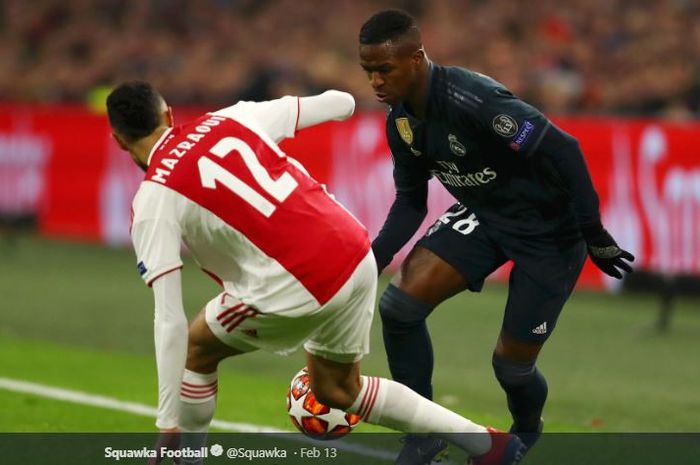 Winger Real Madrid, Vinicius Junior, berusaha melewati adangan pemain Ajax Amsterdam,  Noussair Mazraoui, dalam laga leg pertama babak 16 besar Liga Champions di Amsterdam Arena, 13 Februari 2019.