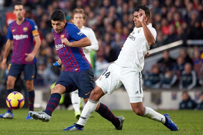 Gelandang Real Madrid, Casemiro, berupaya menahan laju penyerang Barcelona, Luis Suarez, pada laga El Clasico, Oktober 2018.    