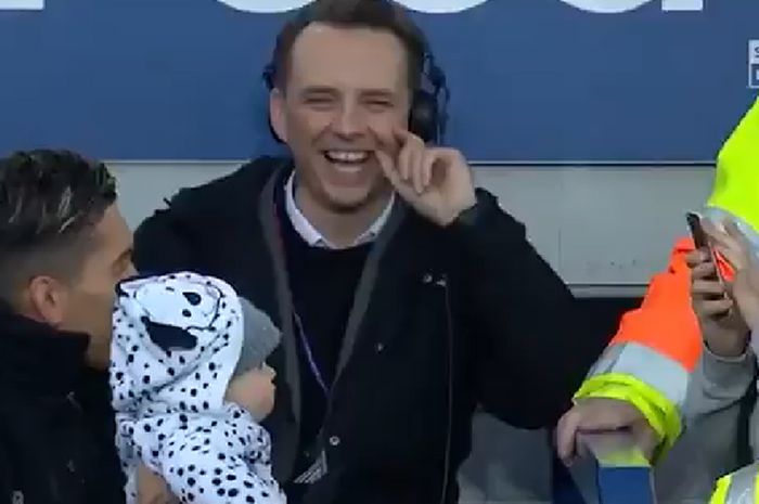 Pemain Liverpool, Roberto Firmino (kiri), berpose dengan seorang anak kecil di tengah pertandingan melawan Everton dalam pekan ke-29 Liga Inggris di Stadion Goodison Park, 3 Maret 2019.