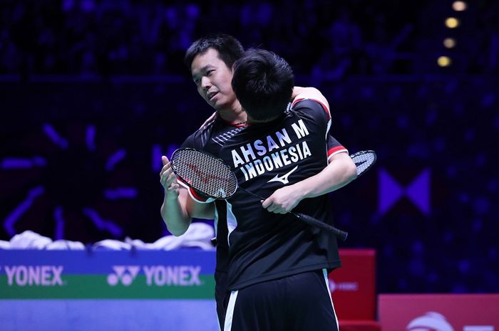 Pasangan ganda putra Indonesia, Mohammad Ahsan/Hendra Setiawan, berpelukan setelah memastikan diri sebagai juara All England 2019 di Arena Birmingham, Inggris, Minggu (10/3/2019).