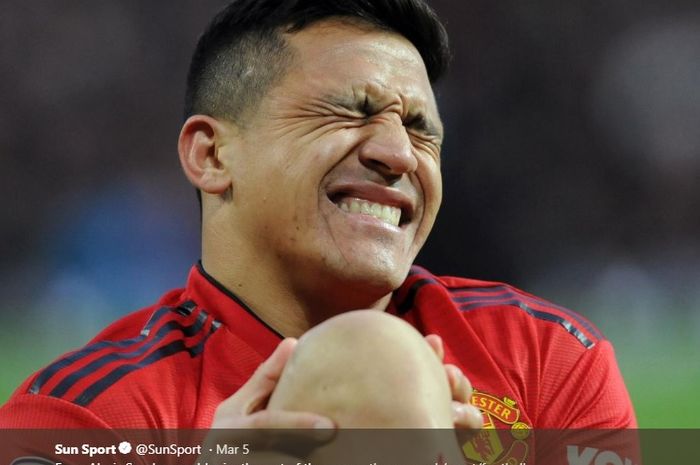 Penyerang Manchester United, Alexis Sanchez, sedang meringis kesakitan.