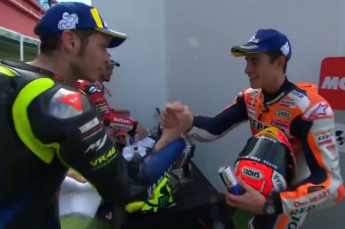 Momen saat Valentino Rossi (kiri) dan Marc Marquez (kanan) berjabat tangan sesaat sebelum prosesi penyerahan trofi MotoGP Argentina 2019 dilakukan.