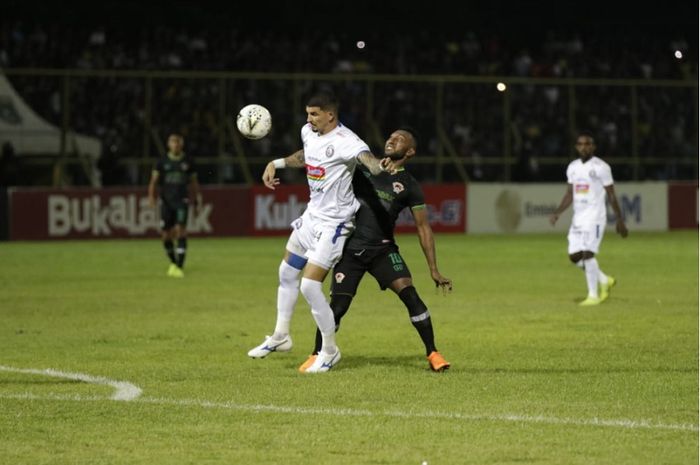 Bek Arema FC Arthur Cunha (kiri) menghalangi striker Kalteng Putra Patrich Wanggai saat berebut bola dalam semifinal leg kedua Piala Presiden 2019 di Stadion 17 Mei, Banjarmasin, Jumat (5/4/2019) malam WIB.