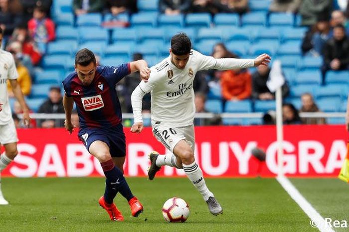 Pemain Real Madrid, Marcos Asensio, berebut bola dengan gelandang Eibar, Sergio Alvarez, dalam pertandingan Liga Spanyol di Stadion Santiago Bernabeu, 6 April 2019.