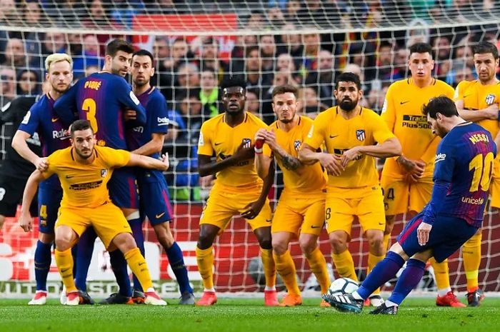 Striker Barcelona Lionel Messi mengeksekusi tendangan bebas ke gawang Atletico Madrid.