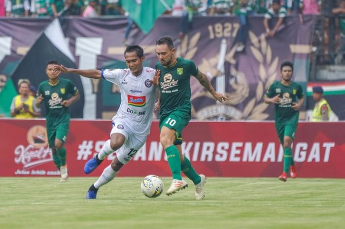 Gelandang serang Persebaya Surabaya Damian Lizio (kanan) diadang pesepak bola Arema FC Hendro Siswanto pada laga final leg pertama Piala Presiden 2019 di Stadion Gelora Bung Tomo, Kota Surabaya, Selasa  (9/4/2019) sore WIB.