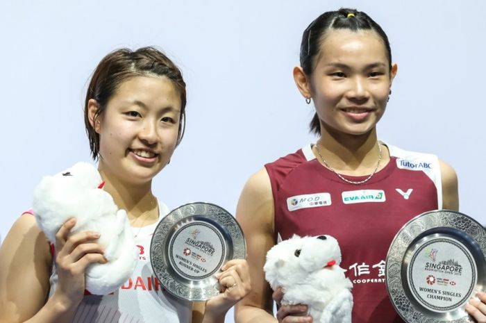 Pebulu tangkis tunggal putri asal Jepang, Nozomi Okuhara (kiri), saat berpose di atas podium Singapore Open 2019 bersama Tai Tzu Ying (Taiwan) di Singapore Indoor Stadium, Minggu (14/4/2019).