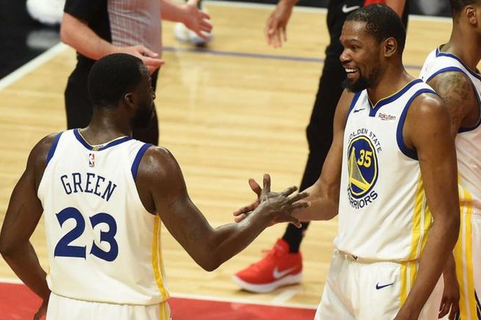 Pebasket bintang Golden State Warriors, Kevin Durant, melakukan tos dengan rekan setimnya, Draymond Green.