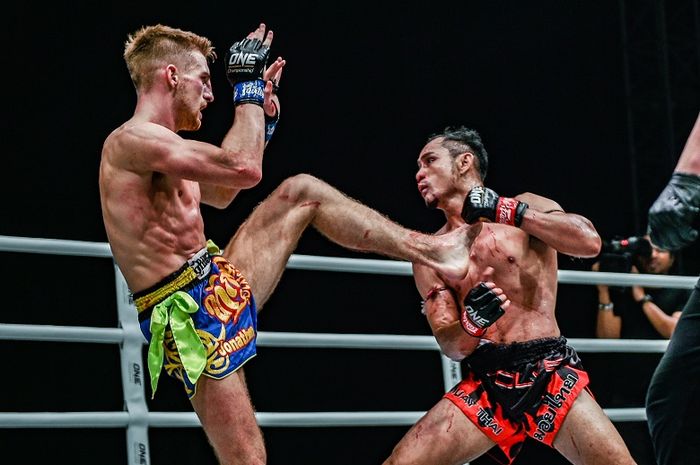 Petarung asal Inggris, Jonathan Haggerty (kiri), melepaskan tendangan ke arah juara dunia ONE Flyweight Muay Thai, Sam-A Gaiyanghadao, dalam ONE: For Honor di Istora Senayan, Jumat (3/5/2019).