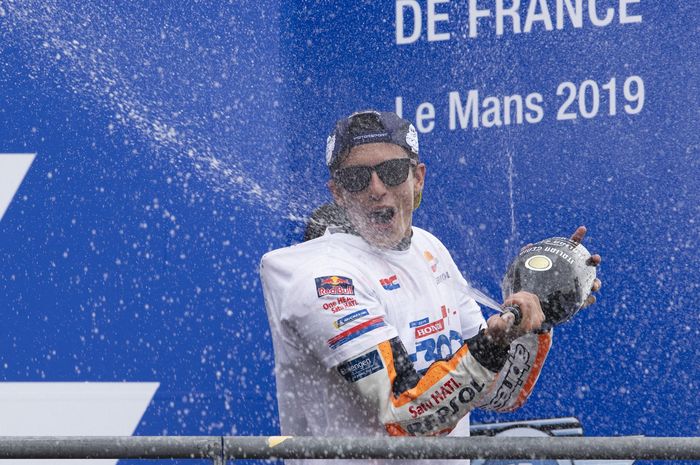 Pembalap Repsol Honda,  Marc Marquez, melakukan selebrasi di Sirkuit Le Mans setelah menjuarai MotoGP Spanyol, Minggu (19/5/2019).