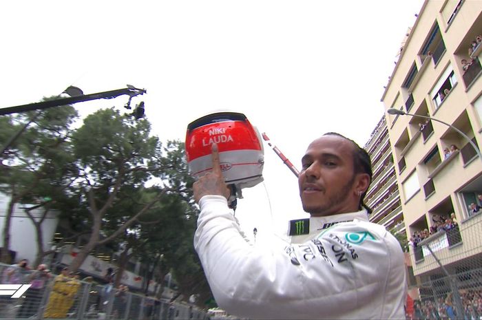 Momen saat Lewis Hamilton (Mercedes) mengangkat helm bertulis Niki Lauda sesaat setelah sukses memenagi F1 GP Monako 2019, Minggu (26/5/2019).