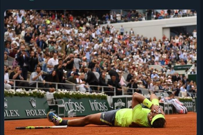 Rafael Nadal terbaring seusai memastikan diri sebagai juara French Open 2019 setelah mengalahkan Dominic Thiem, Minggu (9/6/2019).
