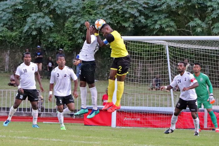 Bek timnas Fiji, Kishan Sami duel udara dengan kapten timnas Vanuatu, Brian Kaltak (kuning) pada laga persahabatan internasional di Stadion Korman, Port Vila pada 10 Juni 2019. 