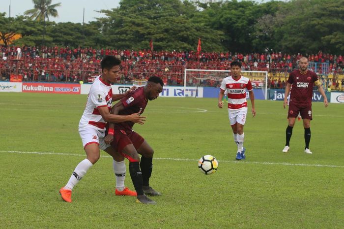 Bek Madura United menjaga ketat penyerang PSM Makassar, Guy Junior pada semifinal pertama Piala Indonesia 2018 di Stadion Andi Mattalatta, Kota Makassar, 30 Juni 2019.