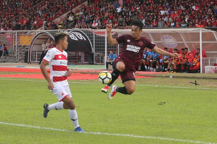 Bek sayap PSM Makassar, Beny Wahyudi melakukan kontrol bola di udara dan diawasi gelandang Madura United, Asep Berlian pada semifinal pertama Piala Indonesia 2018 di Stadion Andi Mattalatta, Kota Makassar, 30 Juni 2019.