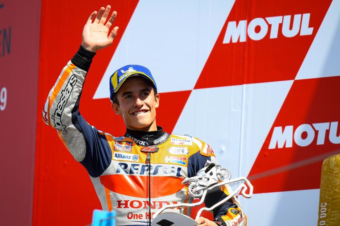 Pembalap Repsol Honda, Marc Marquez, melambaikan tangan di podium MotoGP Belanda di Sirkuit Assen, Minggu (30/6/2019).