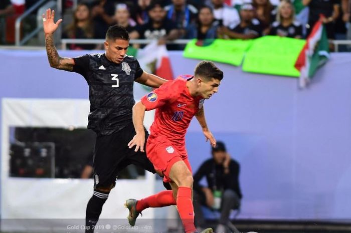 Gelandang timnas Amerika Serikat, Christian Pulisic (depan), berjibaku dengan bek timnas Meksiko, Carlos Salcedo, pada laga final Piala Emas 2019 di Soldier Field, Chicago, 8 Juli 2019.