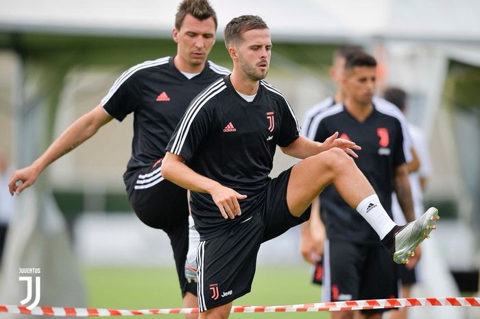 Miralem Pjanic (depan) dan Mario Mandzukic (belakang), menjalani latihan pramusim Juventus pada 10 Juli 2019.