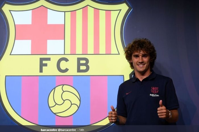 Antoine Griezmann berpose de depan logo Barcelona saat berada di toko resmi klub