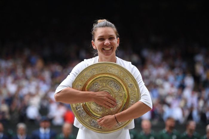 Petenis putri Rumania, Simona Halep, berpose dengan trofi juara setelah memastikan diri meraih gelar Wimbledon 2019, Sabtu (13/7/2019).