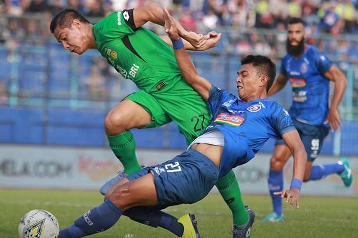 Striker Arema FC, Dedik Setiawan, mendapatkan pengawalan ketat dari bek Bhayangkara FC, Indra Kahfi, pada laga pekan ke-11 Liga 1 2019