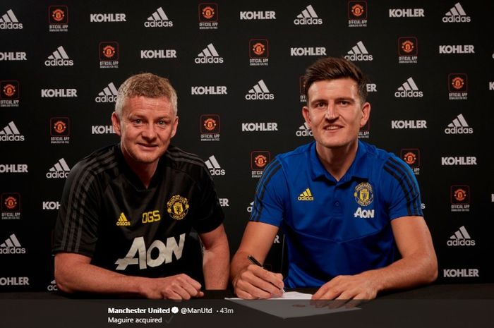 Harry Maguire (kanan) menandatangani kontrak dengan Manchester United didampingi pelatih klub, Ole Gunnar Solskjaer.