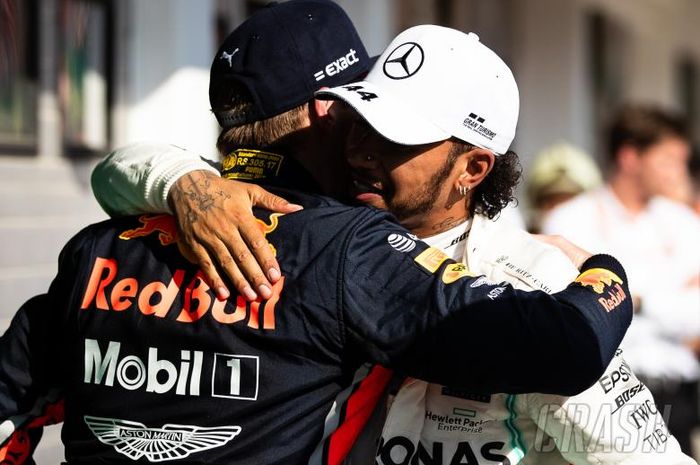 Lewis Hamilton (putih) dan Max Verstappen berpelukan selepas F1 GP Hungaria Minggu (4/8/2019)