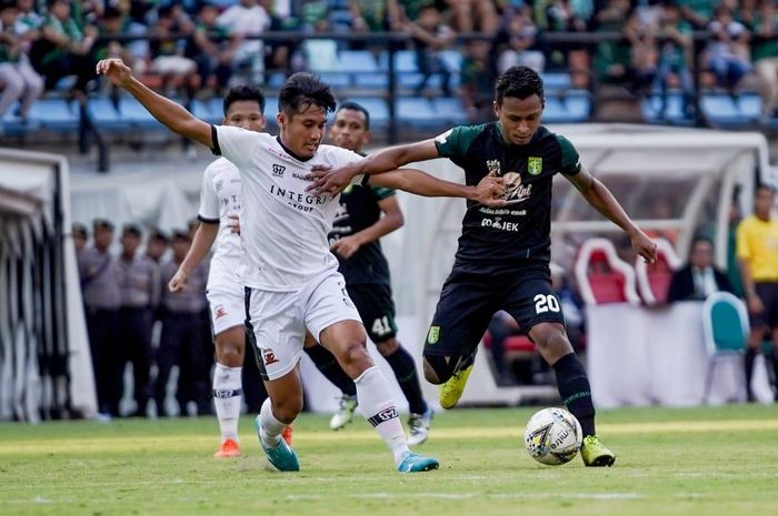 Bek Madura United, Guntur Ariyadi, berduel dengan winger Persebaya Surabaya, Osvaldo Haay, pada laga pekan ke-13 Liga 1 2019.