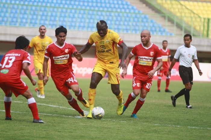 Striker Bhayangkara FC, Herman Dzumafo dikawal ketat pemain-pemain Perseru Badak Lampung FC di Stadion Patriot Chandrabhaga, Kota Bekasi, Jumat (16/8/2019).