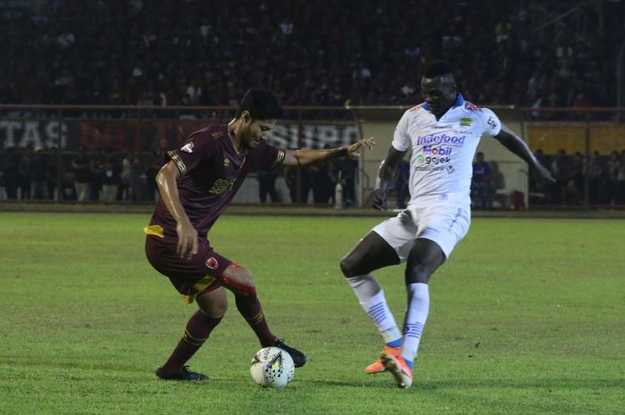 Striker Persib Bandung, Ezechiel Ndouassel, berebut bola dengan bek PSM Makassar, Abdul Rahman, pada laga pekan ke-15 Liga 1 2019.