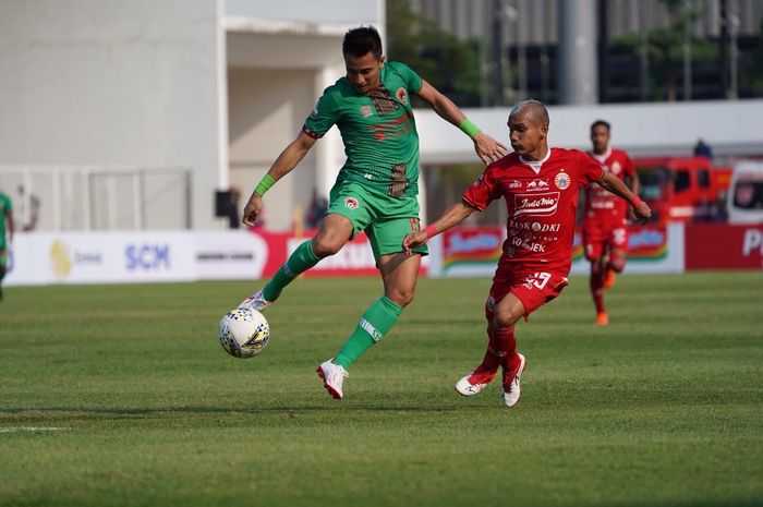 Pemain Persija Jakarta, Riko Simanjuntak, diawasi bek Kalteng Putra, Abdul Rahman Abanda, di Stadion Madya, Senayan, Jakarta Pusat, Selasa (20/8/2019)