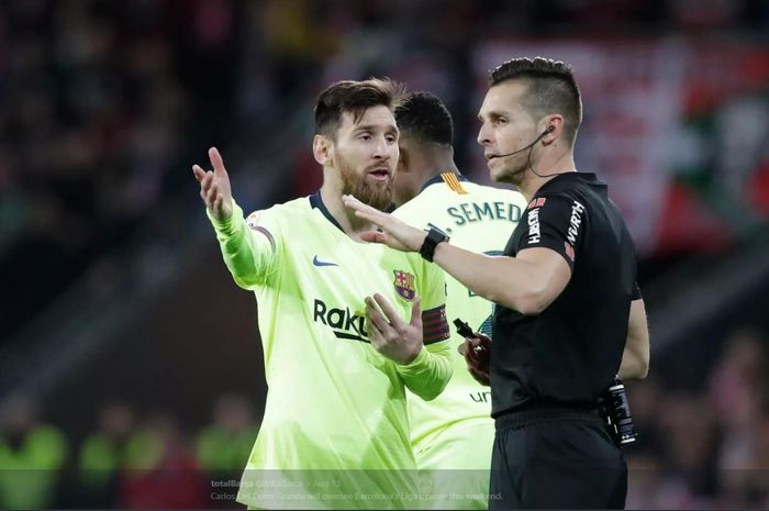 Wasit Carlos Del Cerro Grande (kanan) berbicara dengan Lionel Messi.