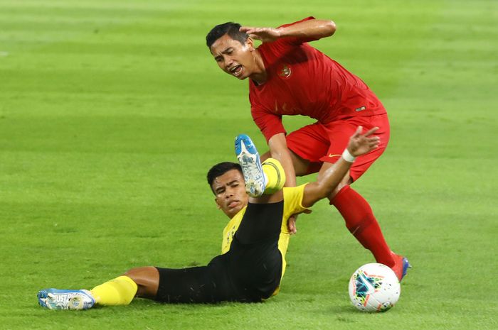 Pemain Timnas Indonesia Ricky Fajrin Saputra berebut bola dengan pemain Timnas Malaysia pada ajang kualifikasi Piala Dunia Qatar 2022 di Stadion Utama Gelora Bung Karno, Jakarta, Kamis (5/9/2019).