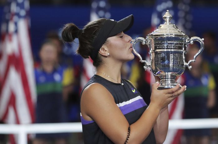 Petenis tunggal putri Kanada, Bianca Andreescu, mencium trofi US Open 2019 yang dia raih usai mengalahkan Serena Williams (Amerika Serikat/AS) pada laga final di Stadion Arthur Ashe, New York, AS, Sabtu (7/9/2019).