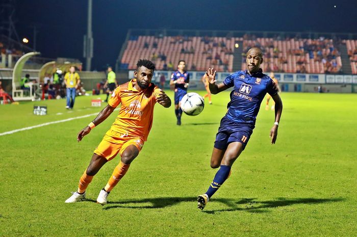 Bek Sukhothai FC asal Indonesia, Rudolof Yanto Basna (kiri) adu lari dengan defender Ratchaburi Mitr Phol FC, Steven Lagil pada laga pekan ke-28 Liga Thailand 1 2019 di Stadion Thalay Luang, 2 Oktober 2019.