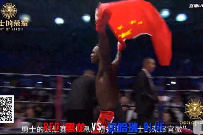 Israel Adesanya merayakan kemenangan di ring dengan bendera China. 