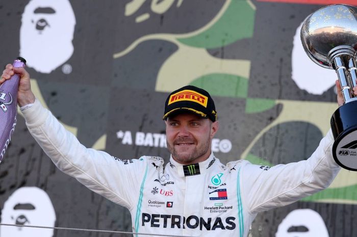 Pembalap Mercedes asal Finlandia, Valtteri Bottas, berpose dengan trofi kemenangan setelah menjuarai GP Jepang 2019 di Sirkuit Suzuka, Minggu (13/10/2019).