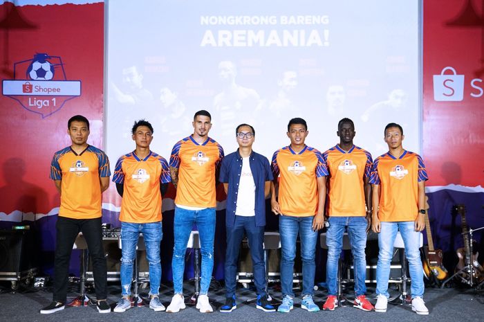 Rezki Yanuar (tengah) selaku Country Brand Manager Shopee diapit enam pemain klub Liga 1, Arema FC yaitu Hamka Hamzah, Johan Alfarizi, Arthur Cunha, Dedik Setiawan, Makan Konate, serta Dendi Santoso (kiri ke kanang) pada acara Nongkrong Bareng Aremania di Eiskaffee, Kota Malang, 6 November 2019. 