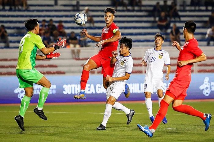 Kapten timnas U-22 Singapura, Irfan Fandi, saat berebut bola dengan pemain Laos pada cabor sepak bola SEA Games 2019.