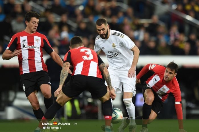 Karim Benzema mencoba melewati tiga pemain Athletic Bilbao pada pertandingan di Stadion Santiago Bernabeu, Minggu (22/12/2019).