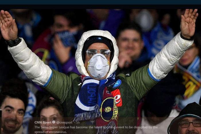 Pendukung Napoli menggunakan masker dalam pertandingan Liga Champions melawan Barcelona di Stadion San Paolo.