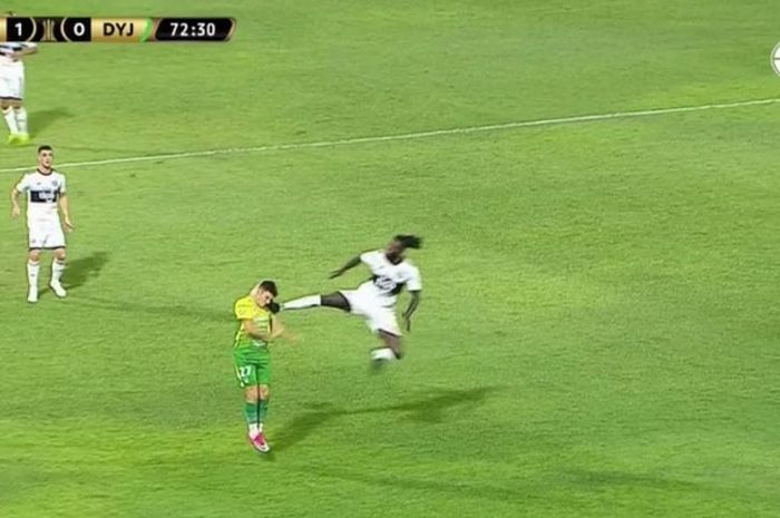 Mantan striker Arsenal, Emmanuel Adebayor, melepaskan tendangan kungfu ke pemain lawan saat membela timnya Olimpia di laga versus Defensa Y Justicia dalam ajang Copa Libertadores, Kamis (12/3/2020).