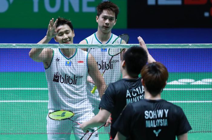 Pasangan ganda putra Indonesia, Marcus Fernaldi Gideon/Kevin Sanjaya Sukamuljo, bersalaman dengan Aaron Chia/Sooh Woi Yik (Malaysia) pada perempat final All England Open 2020 di Arena Birmingham, Inggris, Jumat (13/3/2020).