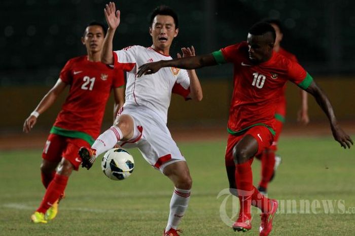 Pemain Timnas Indonesia, Greg Nwokolo (kanan), berebut bola dengan pemain China, Yang Hao, pada pertandingan kualifikasi Piala Asia 2015 di Stadion Utama Gelora Bung Karno (SUGBK), Senayan, Jakarta Pusat, Selasa (15/10/2013) malam. Pertandingan berakhir imbang dengan skor 1-1.